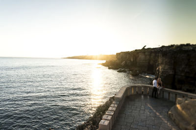 High angle view of couple at observation point by sea against sky