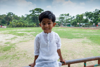 Portrait of smiling boy standing against plants