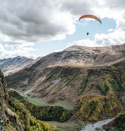 Man flying over mountains against sky