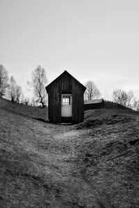 House on field by building against sky