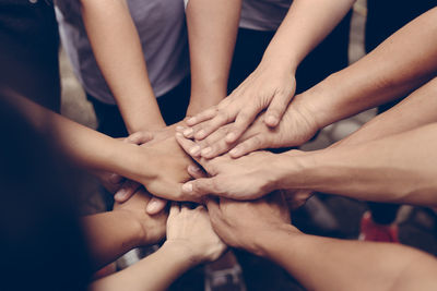 High angle view of friends stacking hands