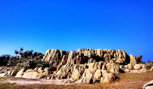 Panoramic view of desert against clear blue sky