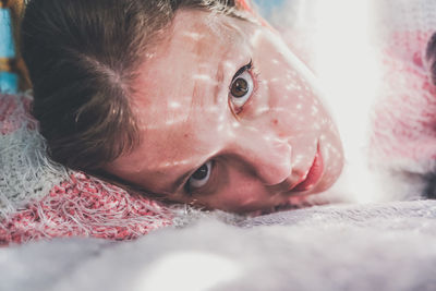Close-up portrait of boy lying on bed