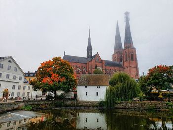 View of temple by building against sky