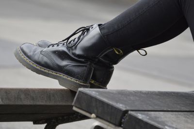 Low section of woman wearing shoes sitting outdoors