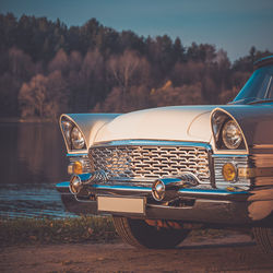 Vintage car on road by lake