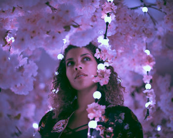 Portrait of beautiful young woman with pink cherry blossom