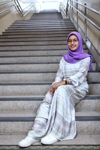 Portrait of young woman sitting on staircase