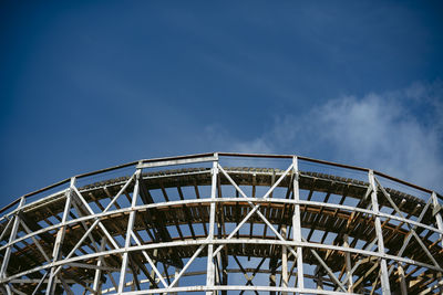 Low angle view of ferris wheel against blue sky