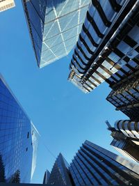 Low angle view of modern buildings against clear blue sky