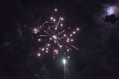 Low angle view of fireworks against sky at night