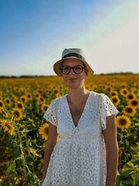 Portrait of young woman standing against sky