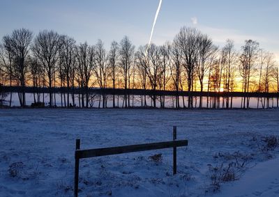 Scenic view of snow covered field against sky during sunset