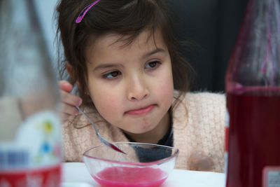 Close-up of girl with juice served in bowl on table