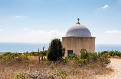 Built structure by sea against sky