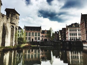 Buildings in city against cloudy sky