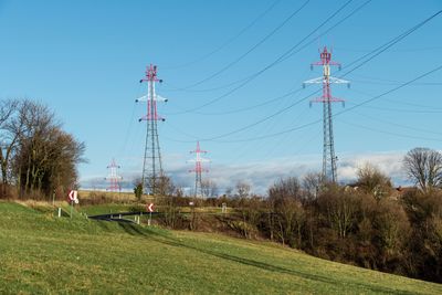 Electricity pylon on field against clear sky