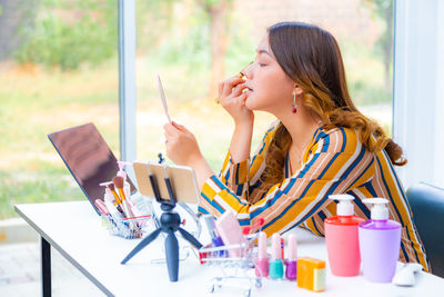 Girl looking away while sitting on table