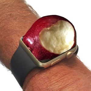 Close-up of hand holding apple against white background