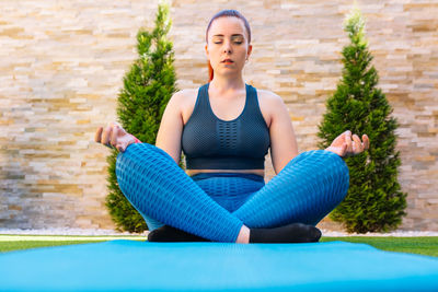 Portrait of young woman sitting on poolside