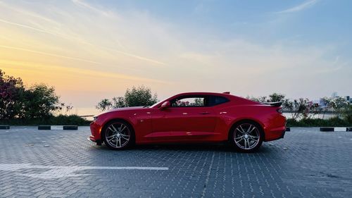 Red vintage car on road against sky