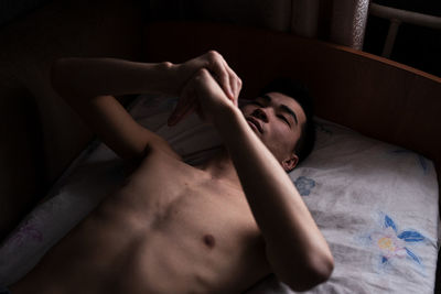 High angle view of young man lying on bed at home