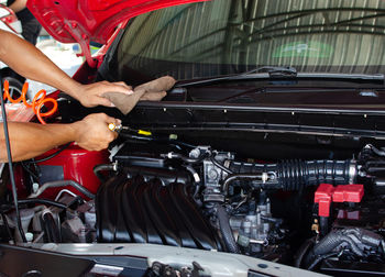 Midsection of man repairing car at garage