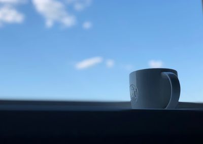 Close-up of coffee cup against sky