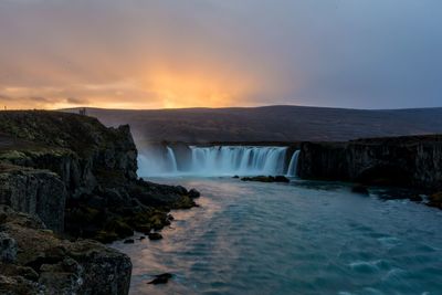 Scenic view of waterfall against sky