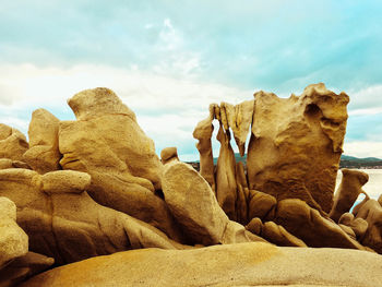 Close-up of rock formation on beach against sky