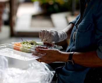 Midsection of man preparing food at market