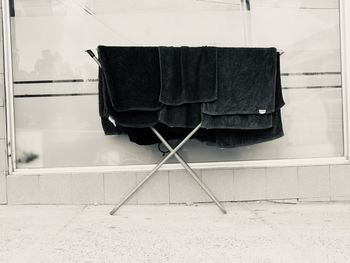 Clothes drying on empty floor against wall