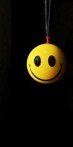 Close-up of stuffed toy hanging against black background