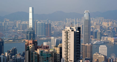 Aerial view of river amidst modern buildings against sky