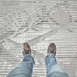 Low section of man standing on tiled floor