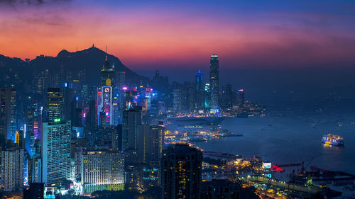 Illuminated view of hong kong against sky at sunset