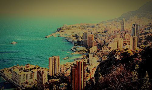 Aerial view of cityscape by sea against sky