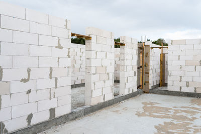 The walls of a house built of white brick with reinforced concrete pillars at the end of which 