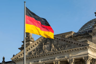 German flag waving front of reichstag building. berlin, germany