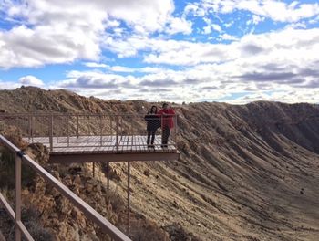 Couple standing on observation point against sky