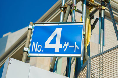 Low angle view of information sign against blue sky