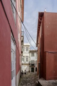 Alley amidst buildings in city against sky