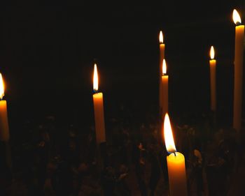 Close-up of candles burning at night