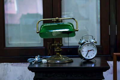 Close-up of clock on table against window
