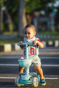 Asian boy playing plow scooter, child cuteness