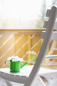 Flowers in watering can on chair