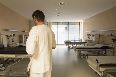 Rear view of man standing in kitchen