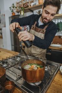 Young man preparing food in kitchen