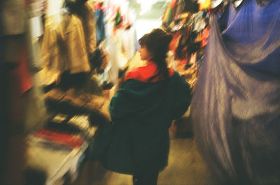 Blurred image of woman walking on street in city
