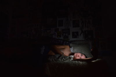 Young women lying in bed illuminated by her smartphone